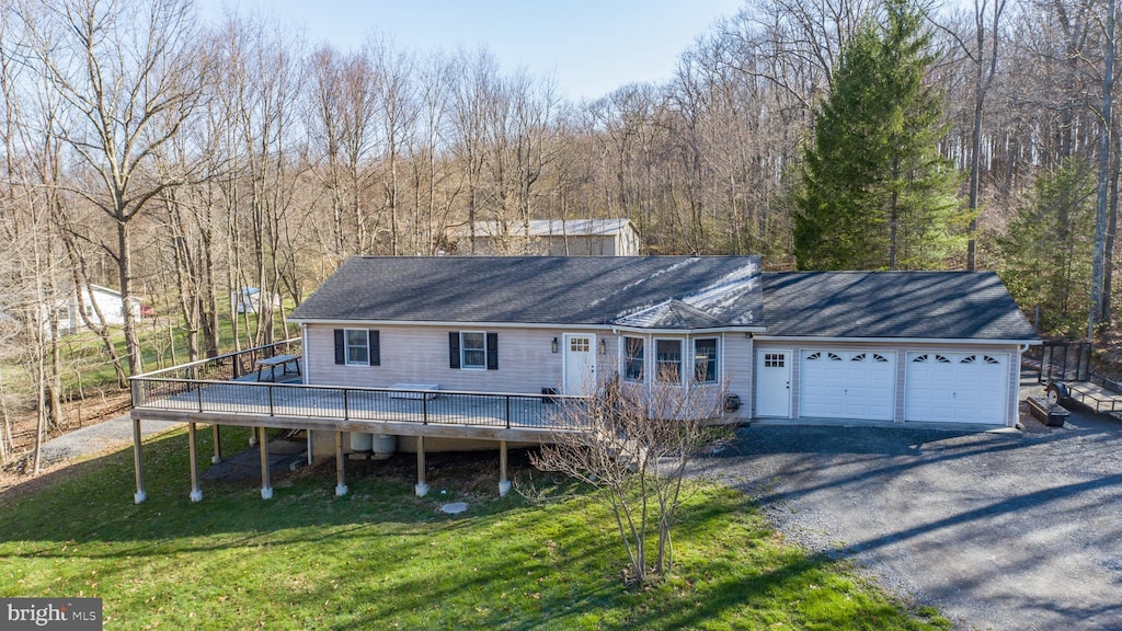 view of front of house with driveway, a front yard, a deck, a garage, and stairs