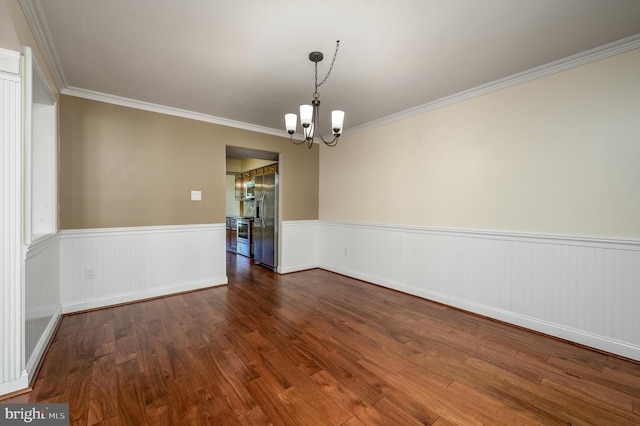 unfurnished room with ornamental molding, dark wood-style flooring, a wainscoted wall, and a chandelier