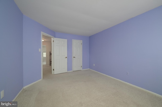 unfurnished bedroom with baseboards and light colored carpet