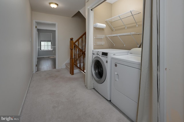 washroom featuring independent washer and dryer, baseboards, and light carpet
