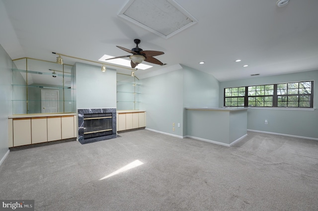 empty room featuring a high end fireplace, baseboards, carpet flooring, and lofted ceiling
