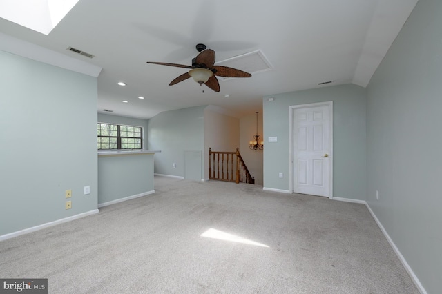 spare room with carpet, ceiling fan with notable chandelier, recessed lighting, lofted ceiling, and visible vents
