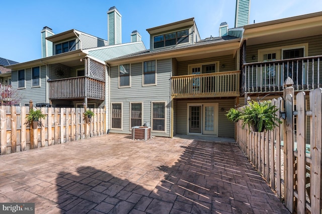back of house with fence, central AC unit, a patio area, and a balcony