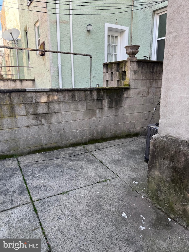 view of patio with central AC unit and fence
