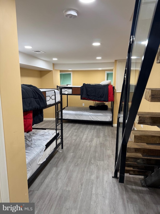 bedroom with visible vents, baseboards, and wood finished floors