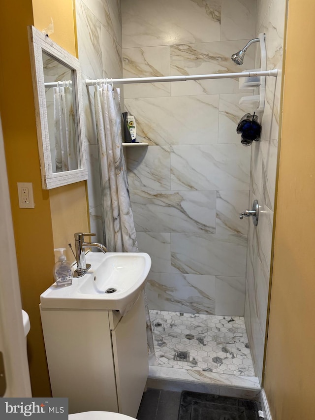 full bath with toilet, vanity, and a stall shower