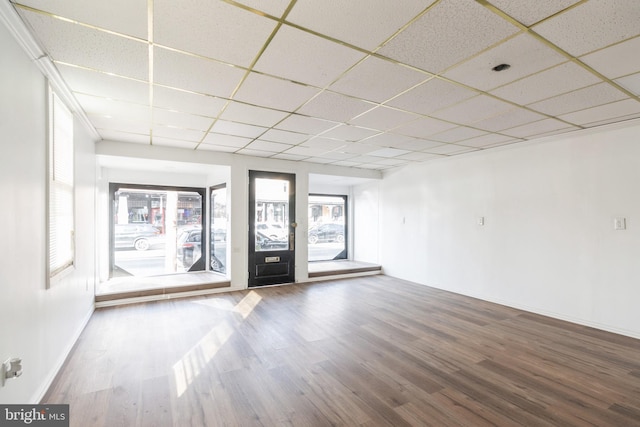 unfurnished room featuring a paneled ceiling, baseboards, and wood finished floors