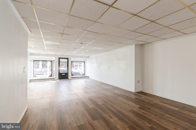 basement featuring a paneled ceiling, wood finished floors, and baseboards