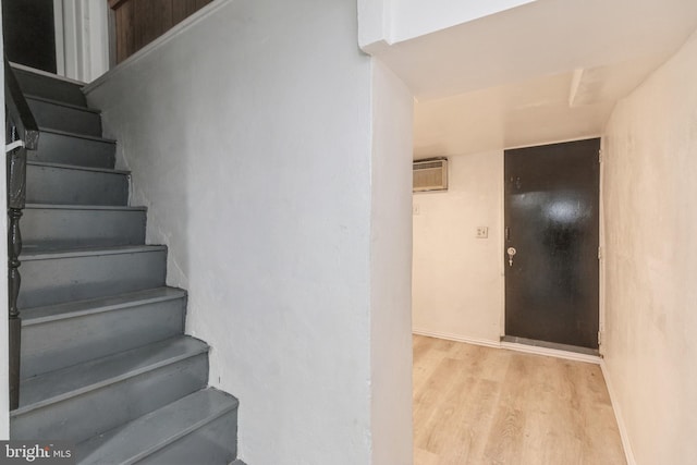 stairway featuring a wall mounted AC and wood finished floors