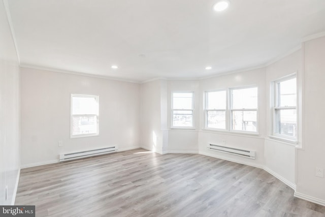 unfurnished room featuring crown molding, plenty of natural light, and a baseboard heating unit