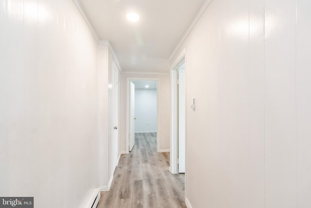 hallway featuring light wood finished floors, baseboards, and ornamental molding