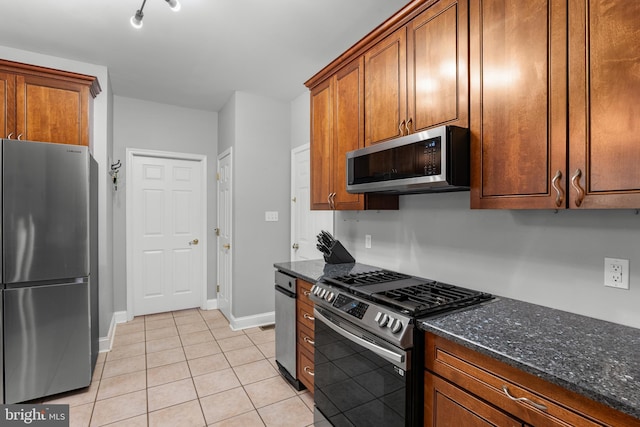 145 Rolling Ave, North East, MD 21901 - kitchen featuring appliances with stainless steel finishes, light tile patterned floors, dark stone countertops, baseboards, and brown cabinets
