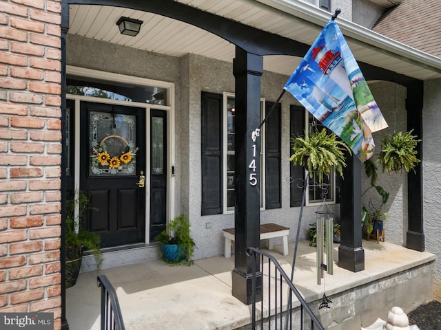145 Rolling Ave, North East, MD 21901 - view of exterior entry with covered porch, stucco siding, and brick siding