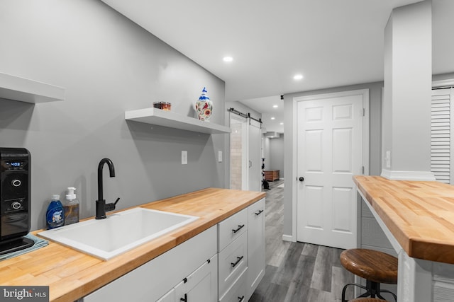 145 Rolling Ave, North East, MD 21901 - kitchen featuring wooden counters, a barn door, a sink, dark wood finished floors, and white cabinetry