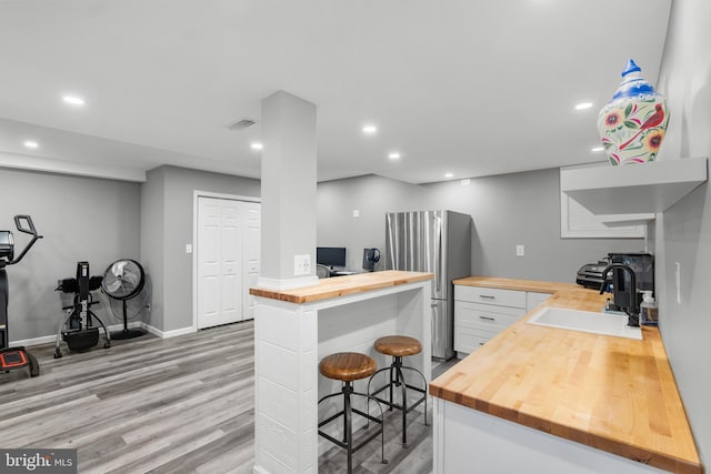 145 Rolling Ave, North East, MD 21901 - kitchen with wooden counters, a breakfast bar, light wood-style flooring, recessed lighting, and white cabinetry