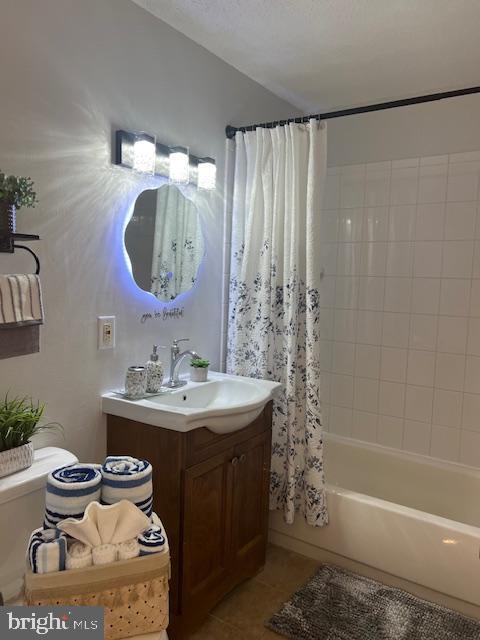 bathroom featuring toilet, vanity, shower / bathtub combination with curtain, and tile patterned floors