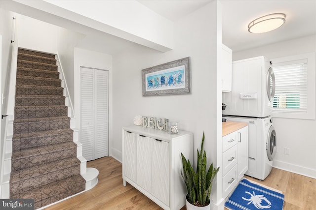 12353 Meadow Dr, Berlin, MD 21811 - washroom with light wood finished floors, laundry area, stacked washer and clothes dryer, and baseboards