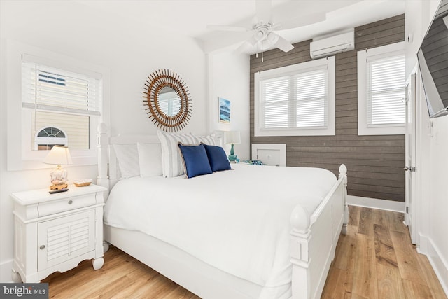 12353 Meadow Dr, Berlin, MD 21811 - bedroom featuring wooden walls, ceiling fan, light wood finished floors, and a wall mounted air conditioner