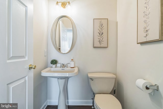 bathroom with baseboards and toilet