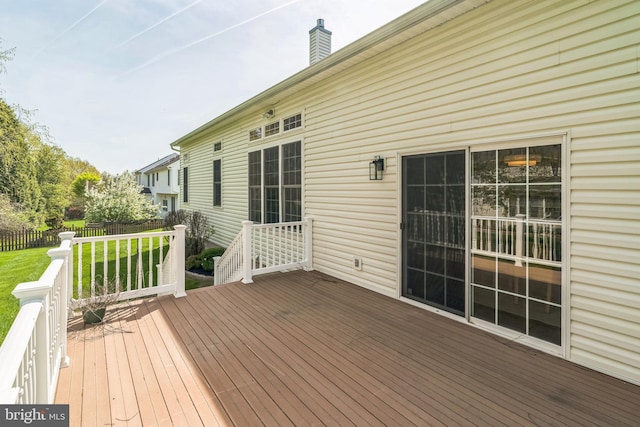deck featuring fence and a lawn