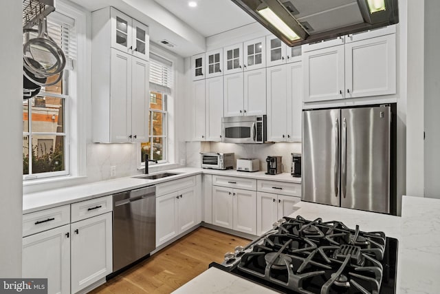 929 S 2nd St, Philadelphia, PA 19147 - kitchen with appliances with stainless steel finishes, a sink, white cabinetry, and light wood-type flooring