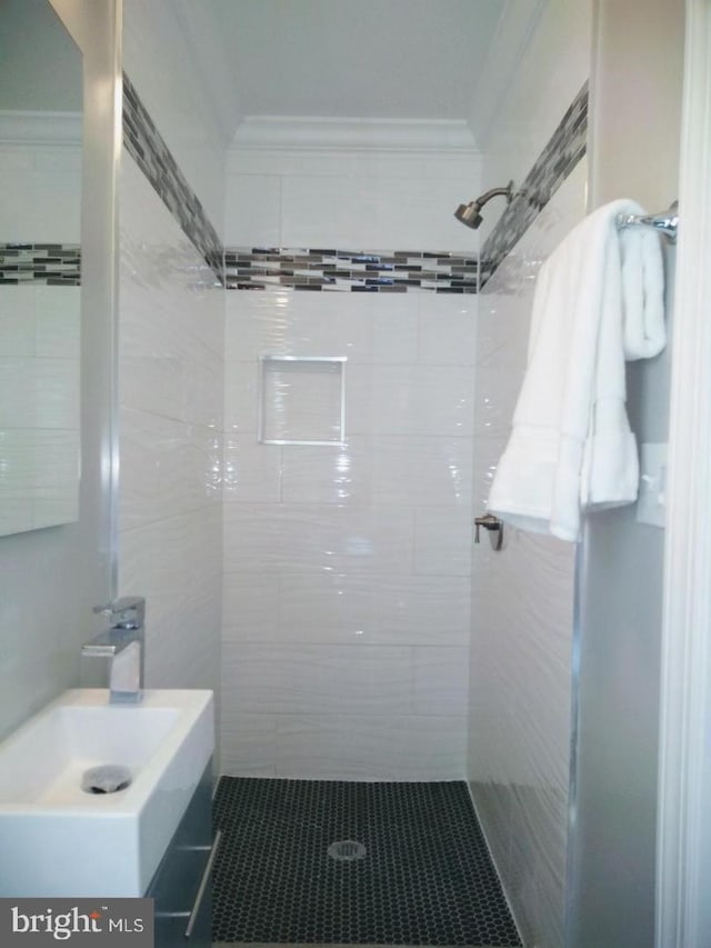 bathroom featuring ornamental molding and tiled shower