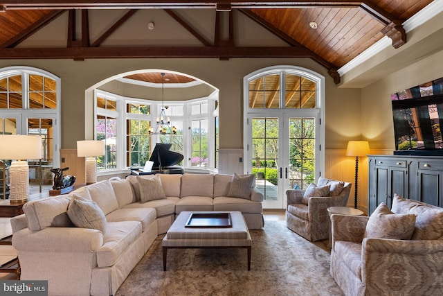 living room with a decorative wall, high vaulted ceiling, french doors, a wainscoted wall, and wood ceiling