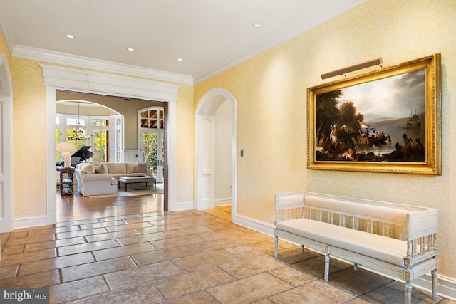 hall featuring crown molding, arched walkways, and baseboards