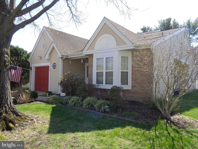 view of front of house with brick siding, a front yard, and an attached garage