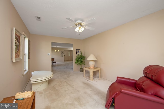 carpeted living area with visible vents, baseboards, and ceiling fan with notable chandelier