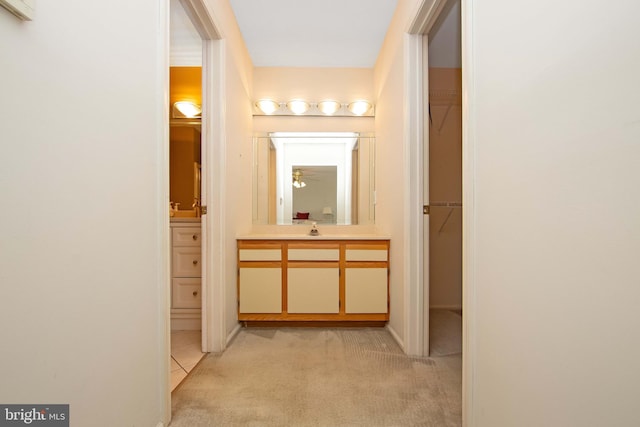 hallway featuring light colored carpet and a sink