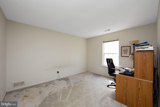 unfurnished office featuring visible vents, baseboards, and carpet floors