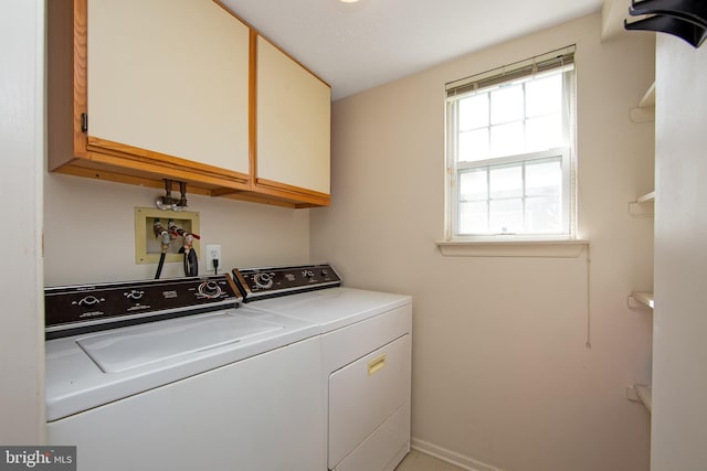 laundry room featuring baseboards, cabinet space, and washer and clothes dryer