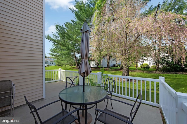 wooden deck featuring outdoor dining area and a yard