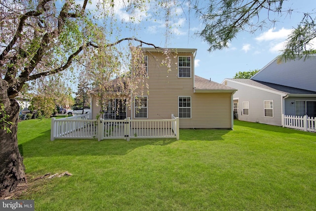 rear view of property featuring fence and a yard