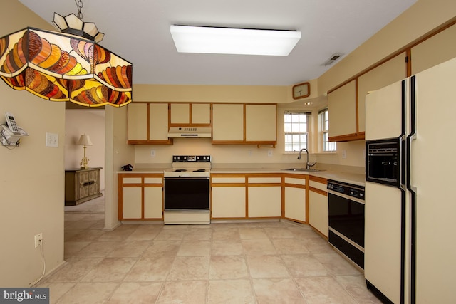 kitchen featuring light countertops, visible vents, under cabinet range hood, and white appliances