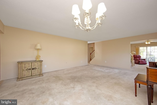 unfurnished living room with light colored carpet, a notable chandelier, and stairs