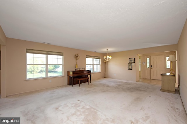 interior space featuring baseboards, an inviting chandelier, and light colored carpet