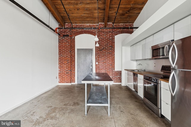 1714 Memphis St Unit 402, Philadelphia, PA 19125 - kitchen featuring concrete floors, white cabinetry, appliances with stainless steel finishes, wood ceiling, and a sink