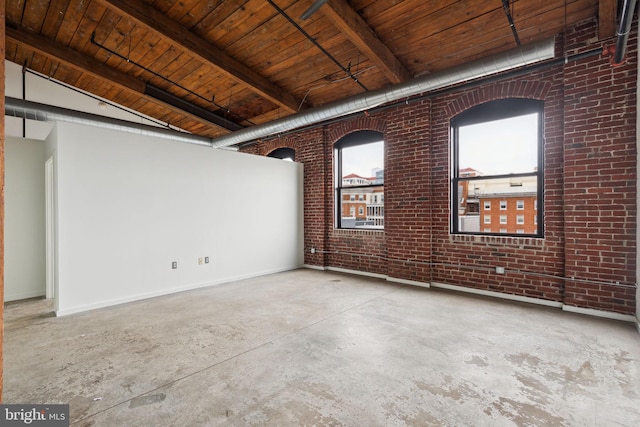 1714 Memphis St Unit 402, Philadelphia, PA 19125 - unfurnished room featuring baseboards, brick wall, wood ceiling, beamed ceiling, and unfinished concrete floors