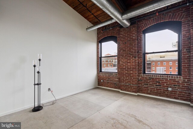 1714 Memphis St Unit 402, Philadelphia, PA 19125 - empty room featuring brick wall, finished concrete floors, and baseboards