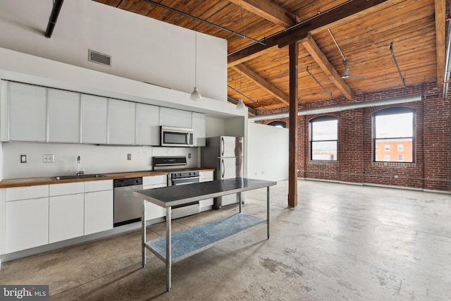 1714 Memphis St Unit 402, Philadelphia, PA 19125 - kitchen featuring visible vents, wood ceiling, appliances with stainless steel finishes, a sink, and brick wall