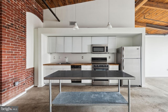 1714 Memphis St Unit 402, Philadelphia, PA 19125 - kitchen featuring gas range, a sink, freestanding refrigerator, stainless steel microwave, and unfinished concrete floors