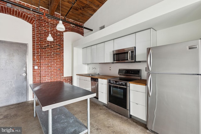 1714 Memphis St Unit 402, Philadelphia, PA 19125 - kitchen with concrete floors, white cabinets, appliances with stainless steel finishes, and wooden ceiling