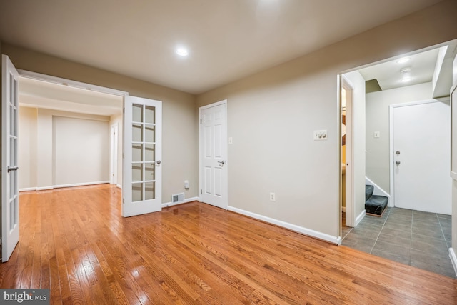 9127 Friars Rd, Bethesda, MD 20817 - empty room with hardwood / wood-style floors, french doors, stairway, and baseboards