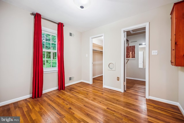 9127 Friars Rd, Bethesda, MD 20817 - unfurnished bedroom featuring wood finished floors, a spacious closet, and baseboards