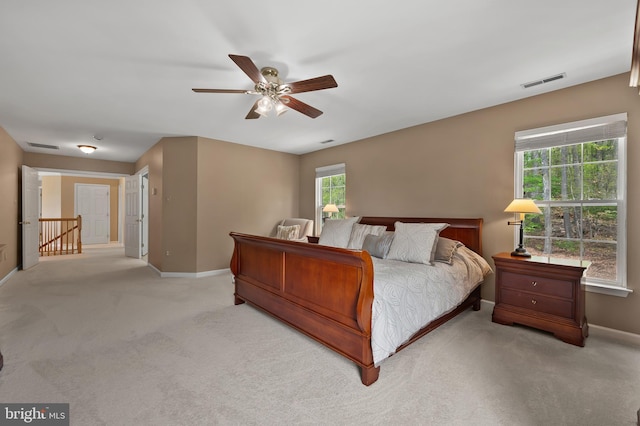 carpeted bedroom featuring baseboards, visible vents, and ceiling fan