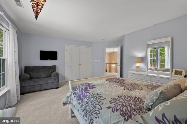 carpeted bedroom featuring visible vents, a closet, and multiple windows