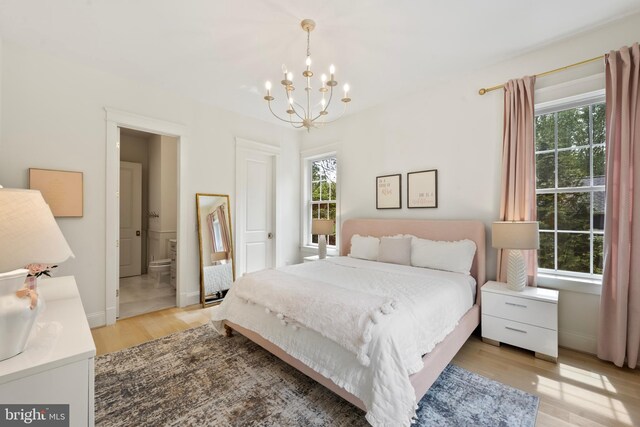 9850 Jerry Ln, Vienna, VA 22180 - bedroom featuring light wood-style floors, a chandelier, ensuite bathroom, and baseboards