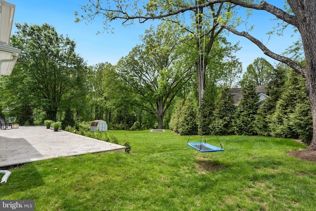 9850 Jerry Ln, Vienna, VA 22180 - view of grassy yard with a storage shed, an outbuilding, and a patio